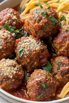 Delicious baked Italian meatballs served in a dish with marinara sauce and herbs.