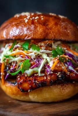 Korean BBQ Chicken Sandwich topped with colorful cabbage slaw on a plate