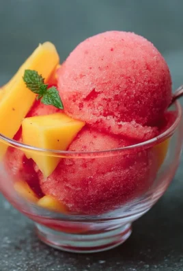 Homemade Mango Strawberry Sorbet in a bowl with fresh fruit garnish