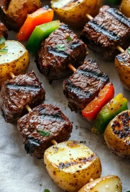 Delicious savory grilled steak and potato kabobs on a platter.