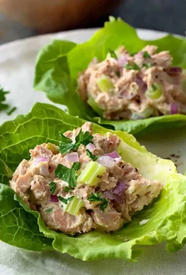 Tuna lettuce wraps filled with fresh ingredients and served on a plate.