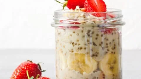 Bowl of colorful overnight oats topped with fruits and nuts