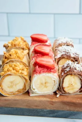 Plate of colorful Banana Sushi rolls with toppings and a drizzle of chocolate.