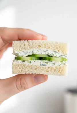 Classic cucumber tea sandwiches on a platter garnished with herbs