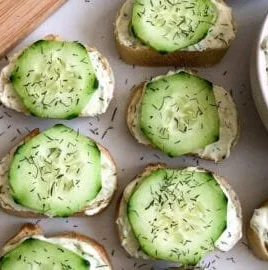 Cucumber Cream Cheese Bites with Mini Baguettes on a serving platter