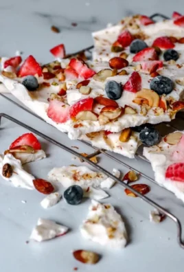 Homemade frozen yogurt bark topped with fresh berries and nuts