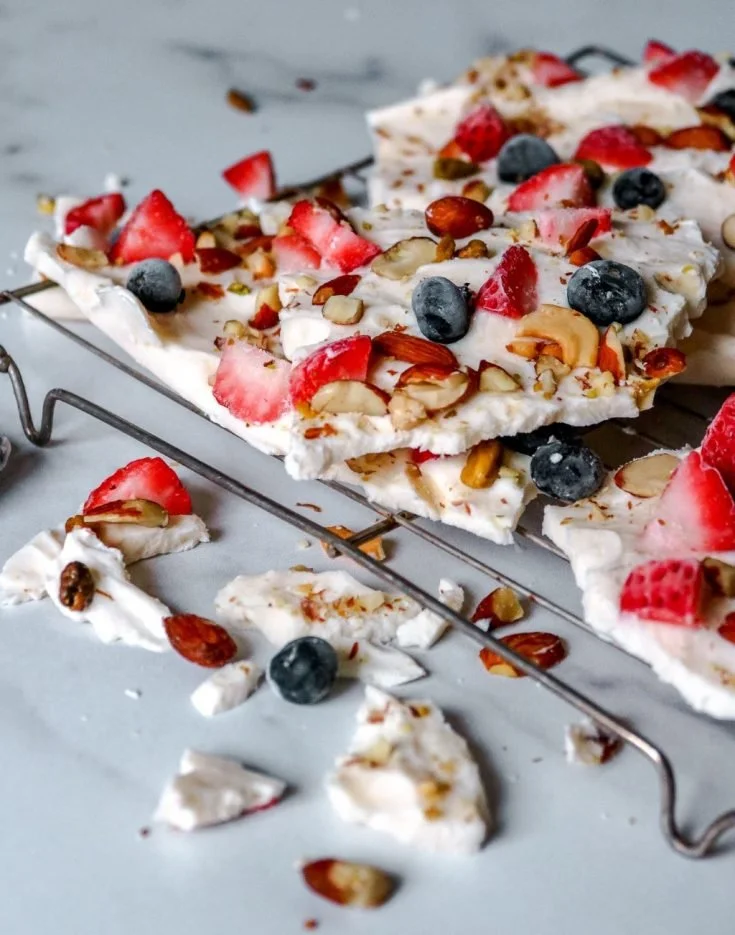 Homemade frozen yogurt bark topped with fresh berries and nuts