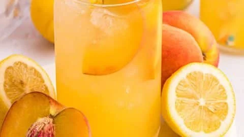 A refreshing glass of peach lemonade with slices of peach