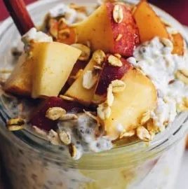 Bowl of Peaches and Cream Overnight Oats topped with fresh peach slices.