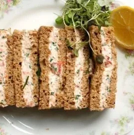 Smoked salmon tea sandwiches on a platter for a charming afternoon tea.