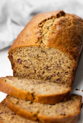 Delicious homemade banana bread loaf with slices on a wooden table.