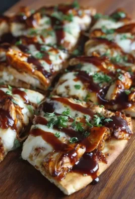 Delicious BBQ chicken flatbread topped with fresh ingredients and drizzled with sauce.