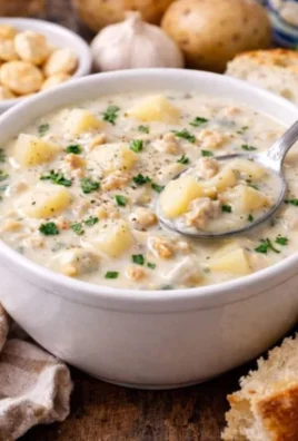 Bowl of creamy homemade clam chowder with potatoes and fresh herbs.