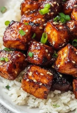 Crispy Honey Garlic Salmon Bites garnished with herbs on a white plate