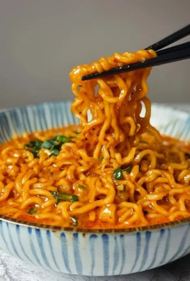 A bowl of spicy Buldak Ramen topped with green onions and chili flakes