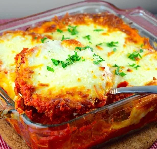 Easy eggplant parmesan dish with cheese and fresh herbs on a plate