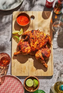 Bottles of fiery Piri Piri Sauce with chili peppers on a wooden table