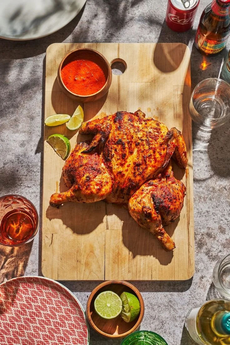 Bottles of fiery Piri Piri Sauce with chili peppers on a wooden table