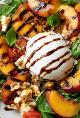 Delicious grilled peach and burrata salad served with fresh greens