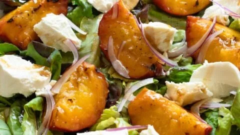 Delicious grilled peach salad with fresh greens and creamy cheese