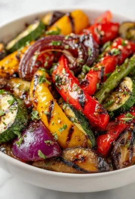 A colorful platter of assorted grilled vegetables including peppers, zucchini, and eggplant.