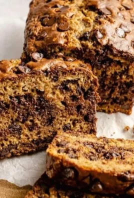 Homemade healthy banana bread with ripe bananas and nuts on a wooden cutting board