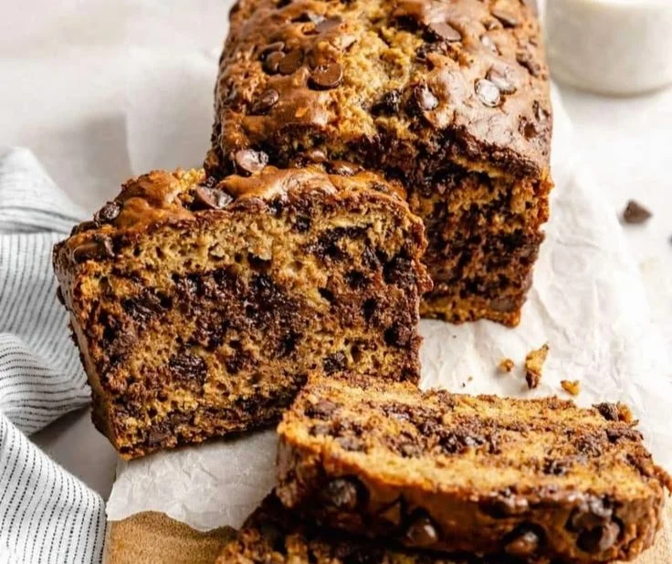 Homemade healthy banana bread with ripe bananas and nuts on a wooden cutting board