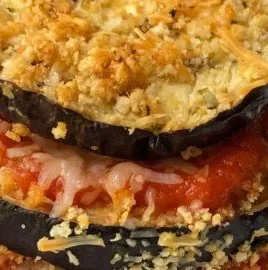 Healthy eggplant parmesan served on a plate with fresh basil garnish