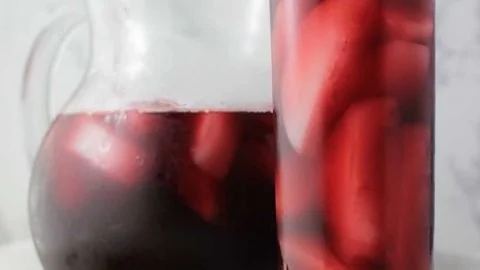 A cup of Hibiscus Ginger Tea with fresh ginger and hibiscus flowers