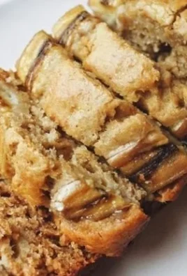Honey Vanilla Banana Bread fresh out of the oven with a golden crust and drizzled honey
