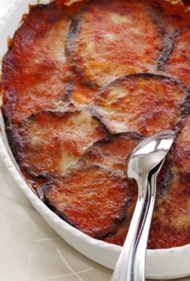 Delicious homemade eggplant parmesan ready to serve with basil garnish.