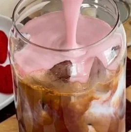Iced Strawberry Mocha with Strawberry Cold Foam in a glass with strawberries