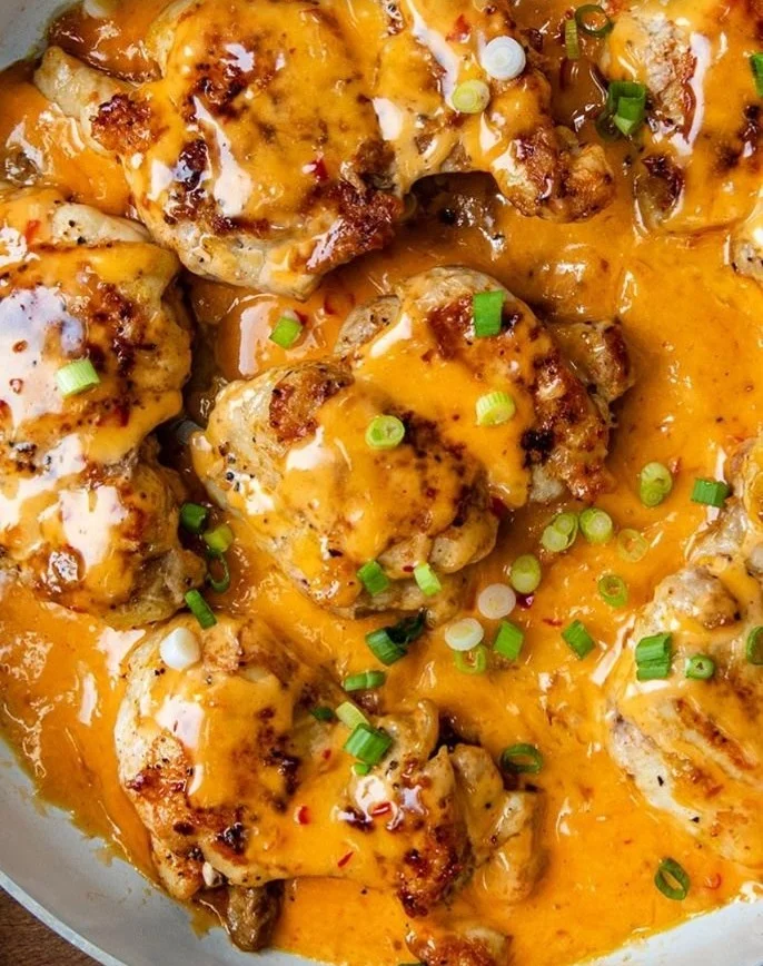 Skillet Bang Bang Chicken Thighs served on a plate with fresh herbs