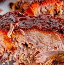 Delicious smoked ribs with a smoky glaze on a wooden platter