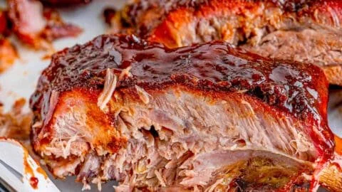 Delicious smoked ribs with a smoky glaze on a wooden platter