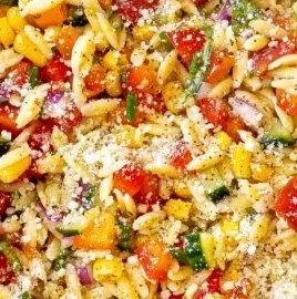 Summer orzo pasta salad with fresh vegetables and herbs