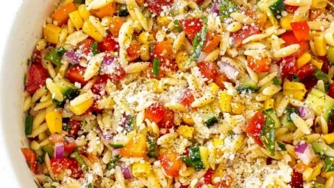 Summer orzo pasta salad with fresh vegetables and herbs