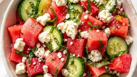 Refreshing watermelon feta cucumber salad served on a plate with mint leaves