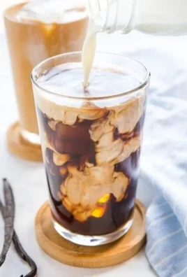 A cup of Vanilla Sweet Cream Cold Brew topped with vanilla cream and served over ice.