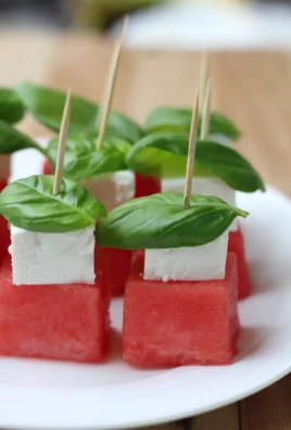Watermelon skewers with feta cheese and fresh basil on a platter