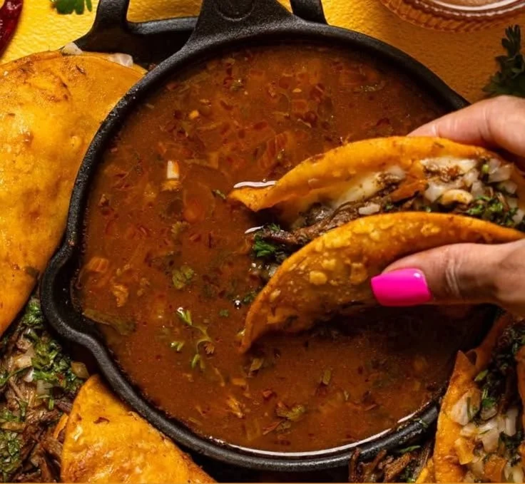 Delicious Birria Tacos served with consome and garnishes