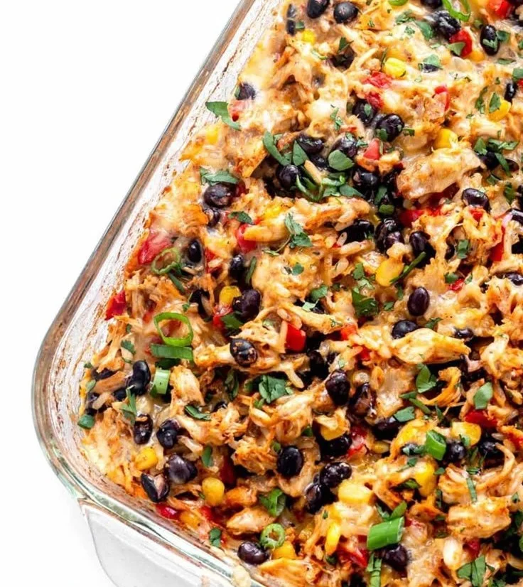 A delicious Chicken Burrito Casserole served in a dish, topped with cheese and fresh ingredients.