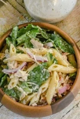Bowl of Chicken Caesar Pasta Salad with lettuce, chicken, and Caesar dressing