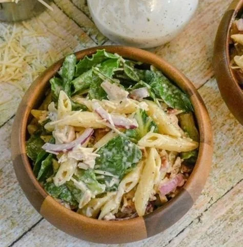 Bowl of Chicken Caesar Pasta Salad with lettuce, chicken, and Caesar dressing