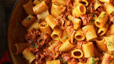 Delicious creamy chorizo pasta topped with herbs in a bowl