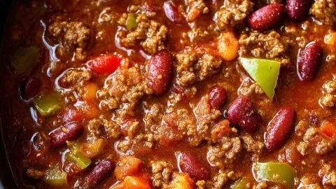 Bowl of easy classic chili topped with cheese and parsley, showcasing comfort food.