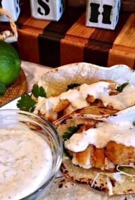 Delicious easy fish tacos garnished with fresh vegetables and lime