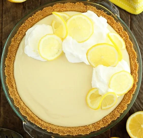 Slice of easy lemon cream pie topped with whipped cream and lemon zest
