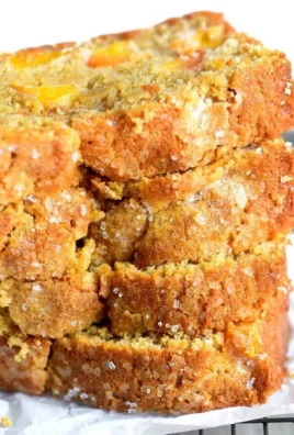 Slice of easy spiced peach bread garnished with fresh peach slices