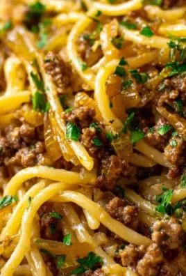 Plate of Garlic Butter Beef Pasta garnished with herbs and served with garlic bread.